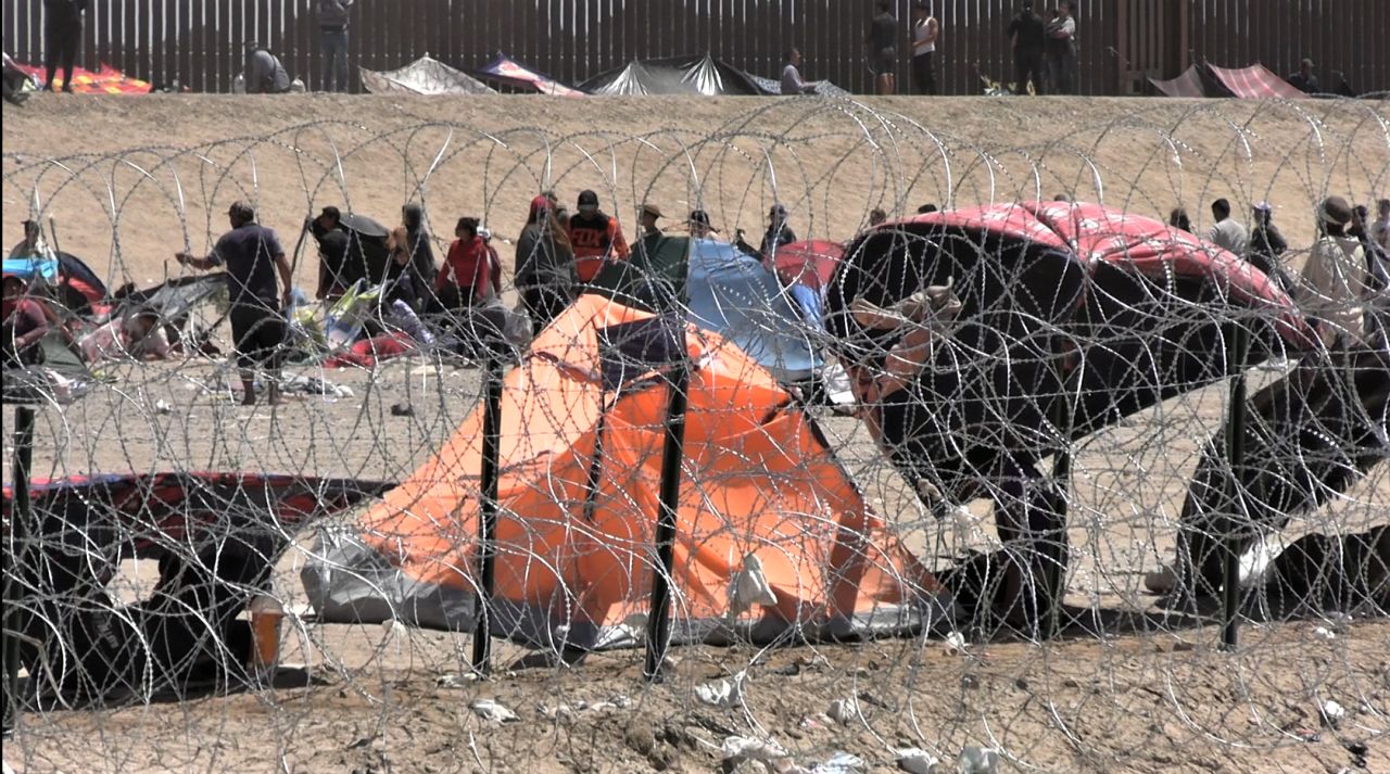 Migrants camp in tents along border wall as processing centers fill up