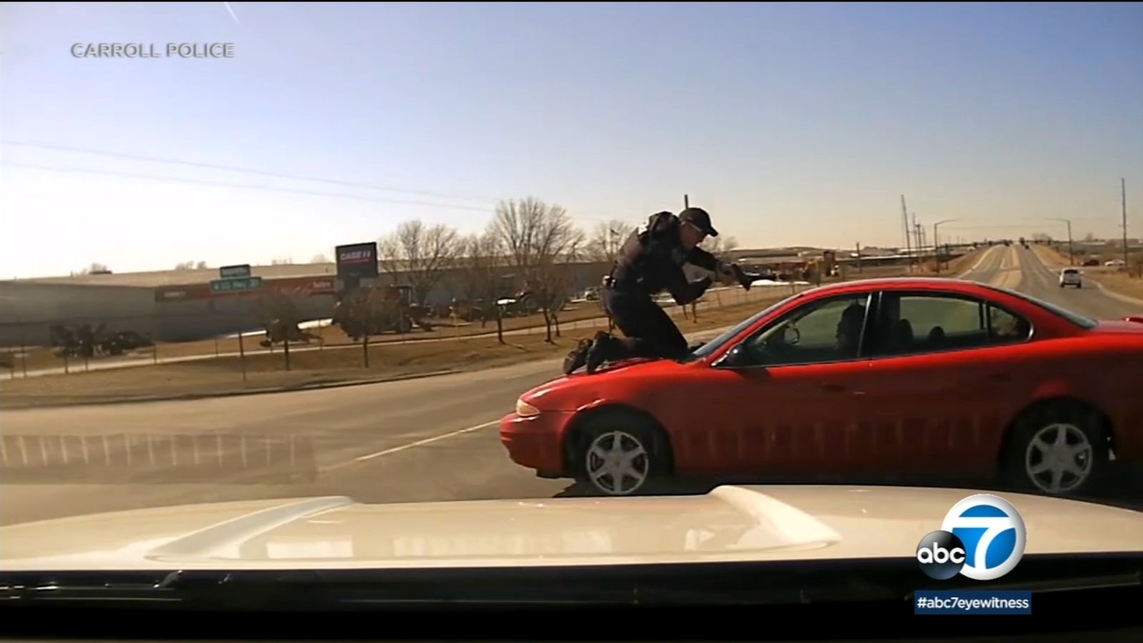 'Stop the car!': Wild video shows police officer holding on to fleeing car with gun aimed at driver