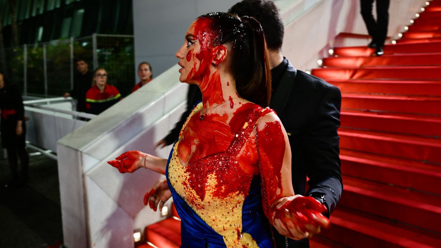 Festival de Cannes 2023 : une femme dans une robe aux couleurs de l'Ukraine s'asperge de faux sang sur le tapis rouge