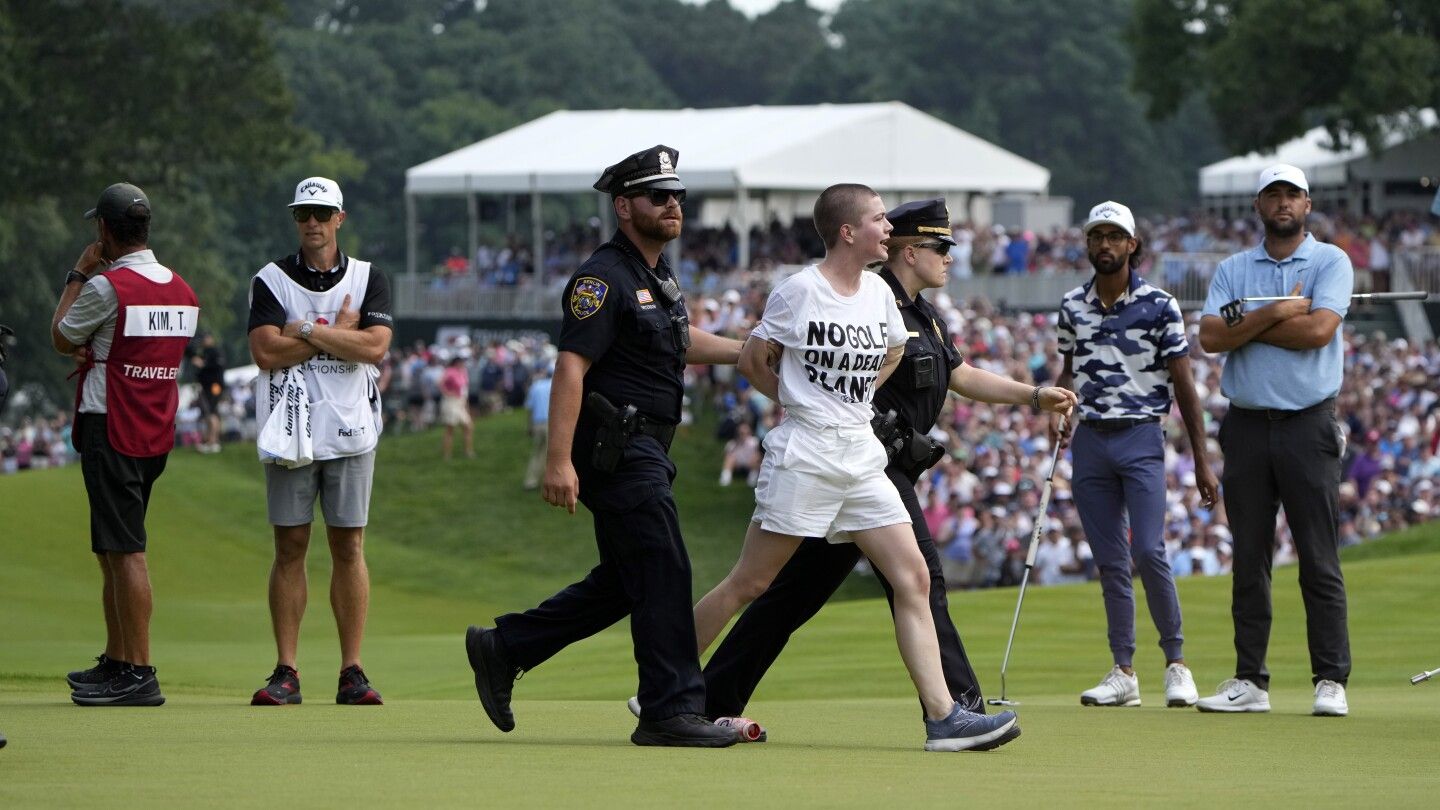 Six climate protesters run onto 18th green and spray powder, delaying finish of PGA Tour event